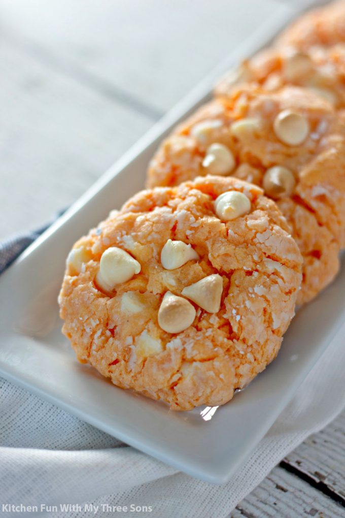 白色盘子上的橙色乳霜蛋糕饼干饼干