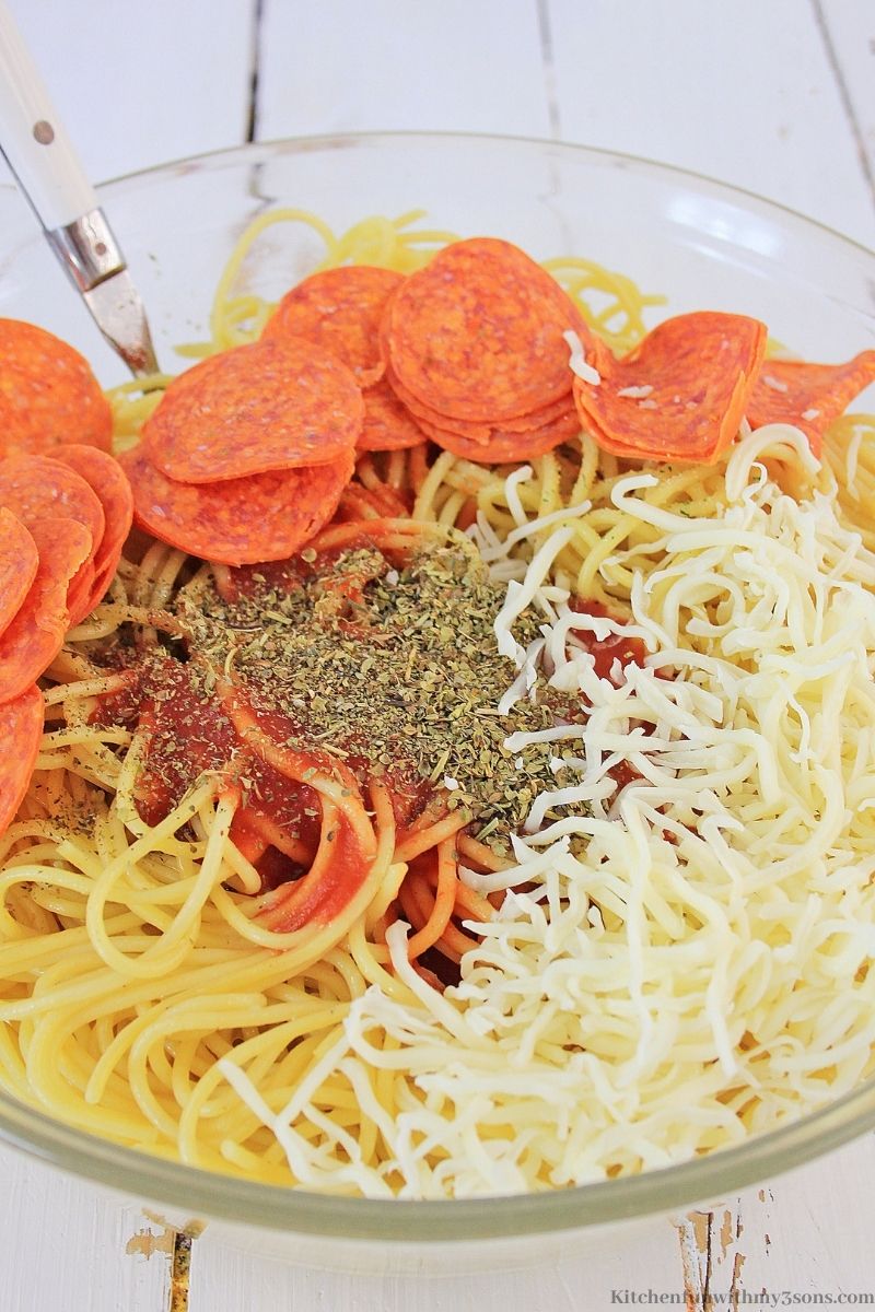 在一个大碗中加入意大利辣香肠，调味料，酱汁和奶酪。