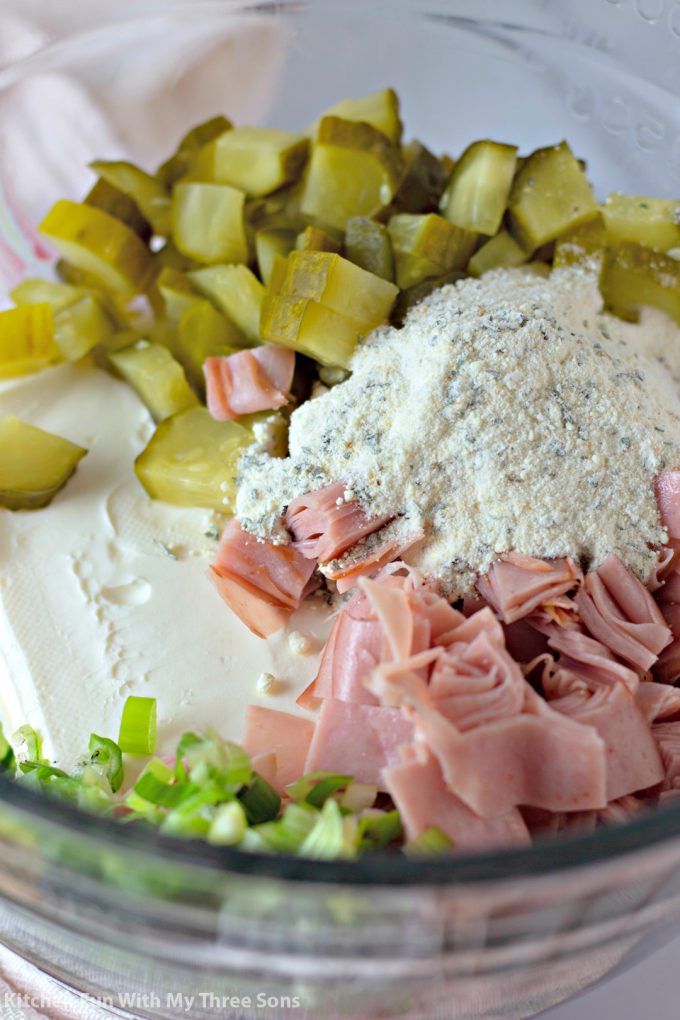 火腿，奶油奶酪，牧场混合物，泡菜和绿色洋葱在透明的面糊碗中