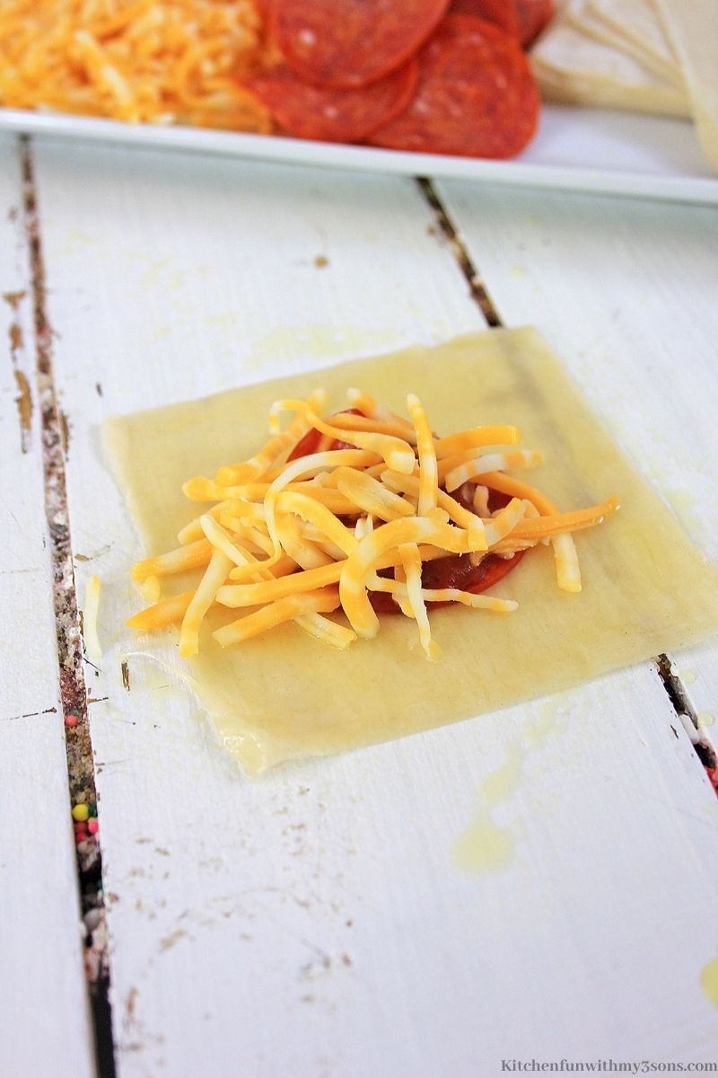在酱汁和意大利辣香肠上撒上奶酪。