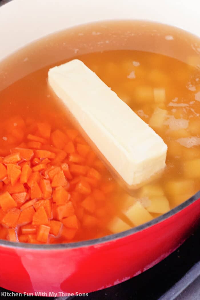 鸡肉汤，土豆，胡萝卜和黄油，里面有一个大红色的锅。