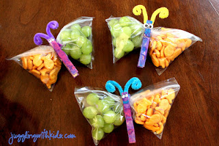 三个蝴蝶零食袋，里面装满了葡萄和金鱼的木表面