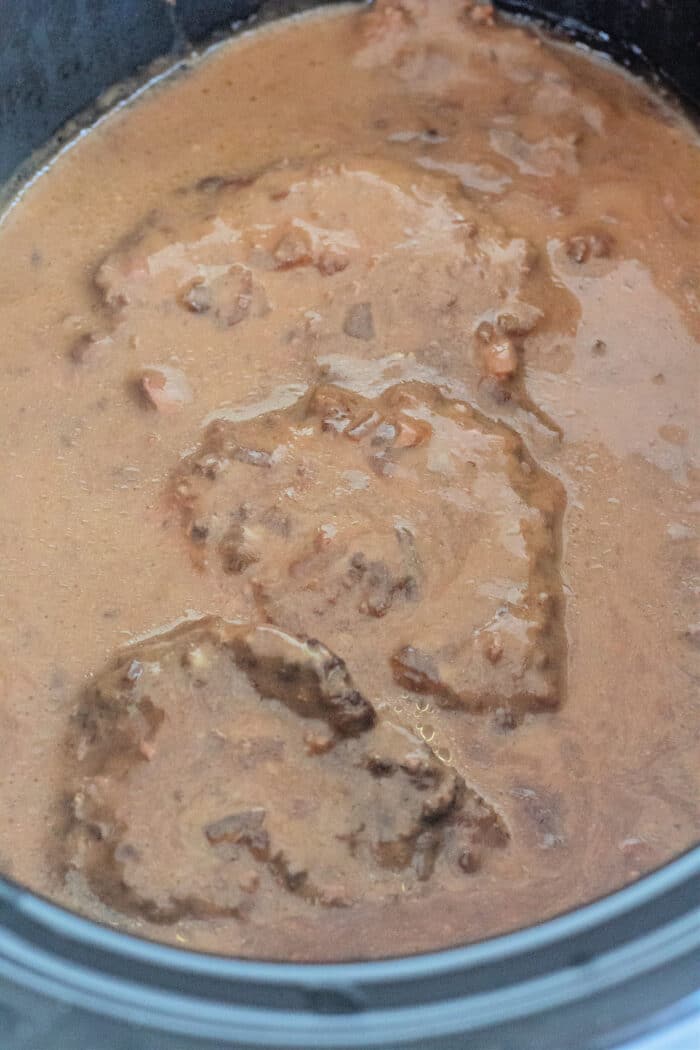 新鲜制作的crock锅立方体牛排，肉汁在黑色慢炖锅中。