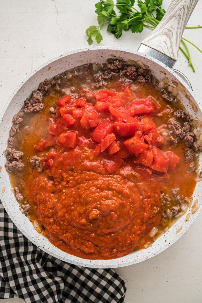 地面牛肉，番茄酱和煎锅中的番茄罐头GydF4y2Ba